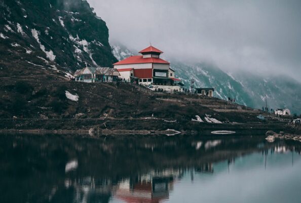 white and red concrete building near body of water