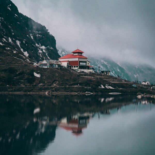 white and red concrete building near body of water